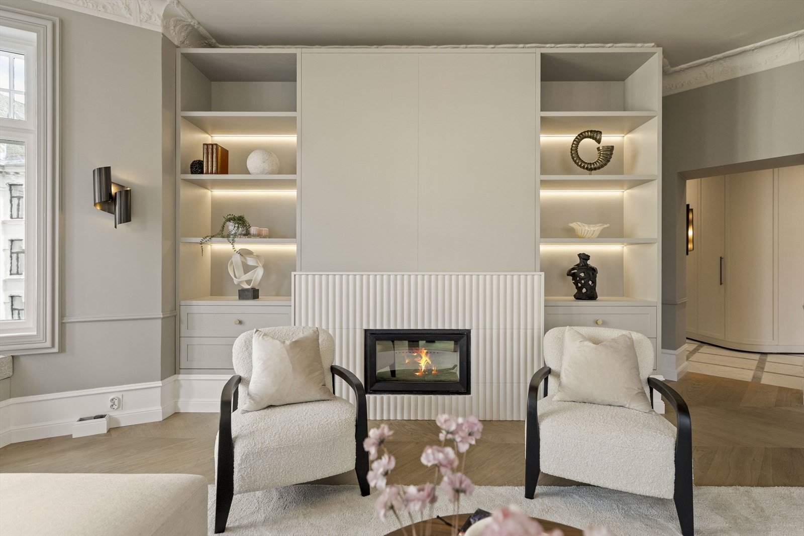 Hjørnestuen er svært lys og oser av eksklusivitet. Hyllene og skuffene er håndlaget av San Miguel Wood Works i Portugal. Peisen er kledd i fliser fra Wow. Galleribilde