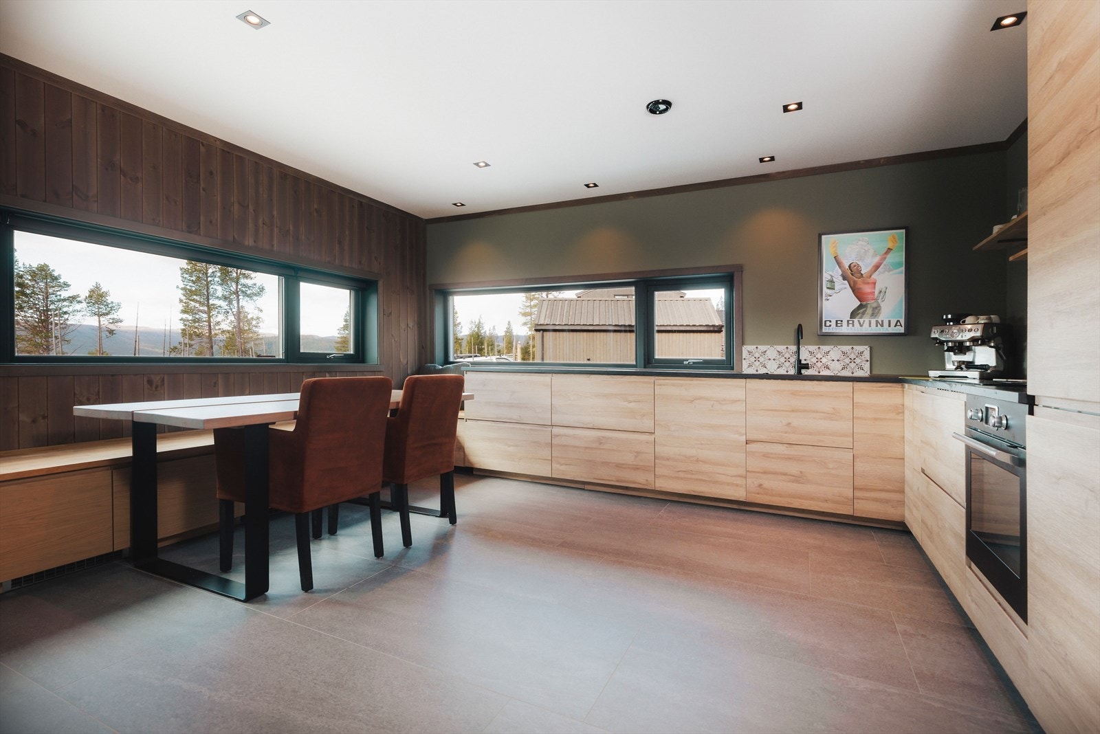 Vinduer på to sider bidrar med mye naturlig lys til matlagingen. Innredningen er oppført i en funksjonell L-form med glatte fronter, nedfelt oppvaskkum og sort benkeplate av laminat. Galleribilde