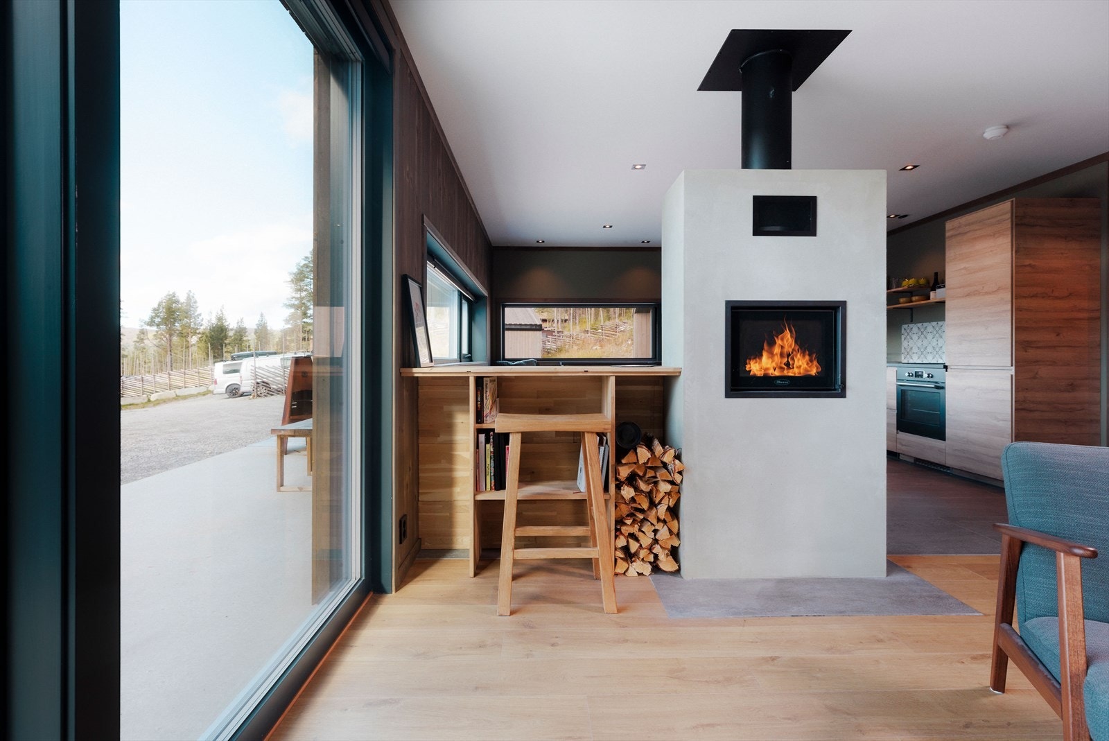 Peisen i moderne stil er gjennomgående og flammene kan nytes fra både stue og kjøkkensiden. Galleribilde