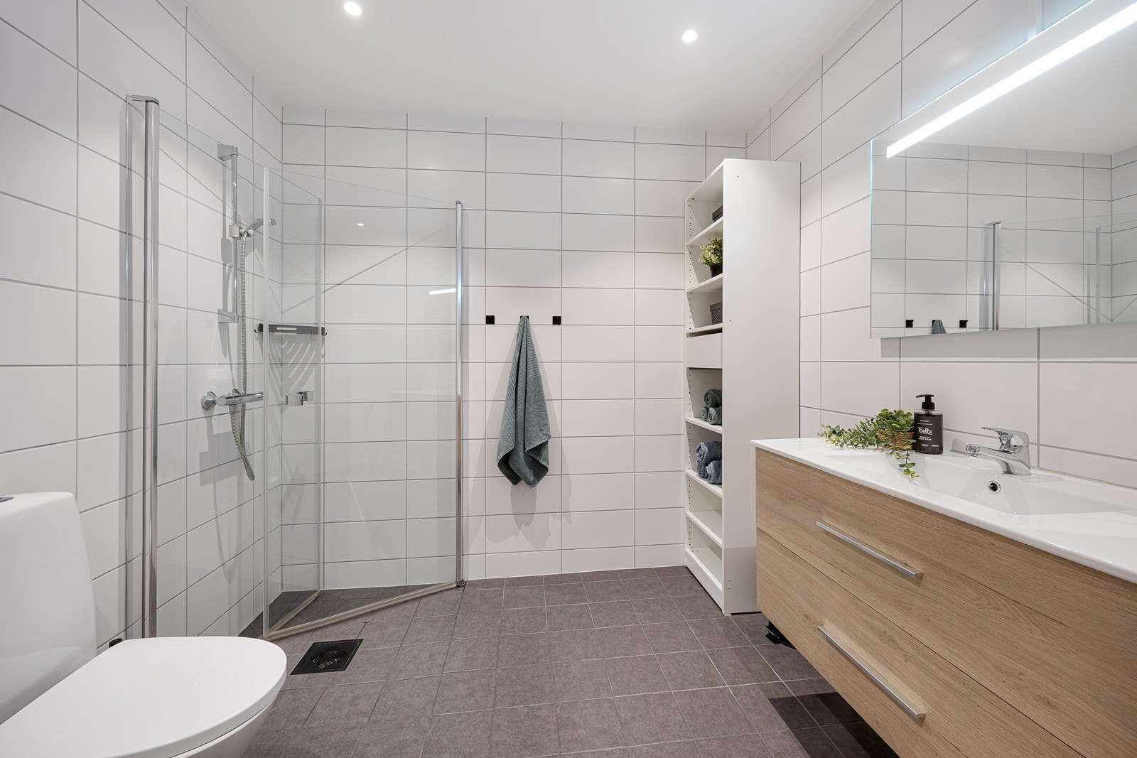 Varme er lagt i gulvet, og badet har toalett, downlights og et dusjhjørne med innfellbare dører i herdet glass. Galleribilde