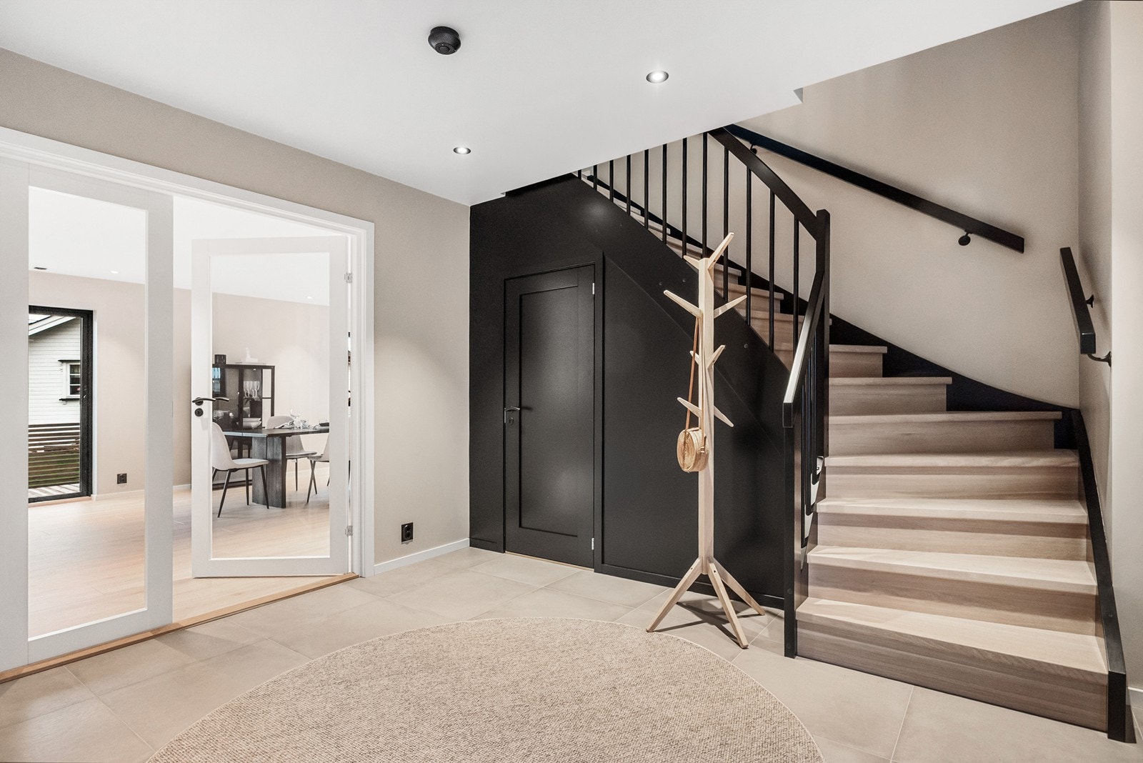 Når du trer inn i hallen møtes du av et lyst og velkomment rom, med flislagt gulv med varme, downlights og en elegant trappeløsning som binder etasjene sammen. Galleribilde