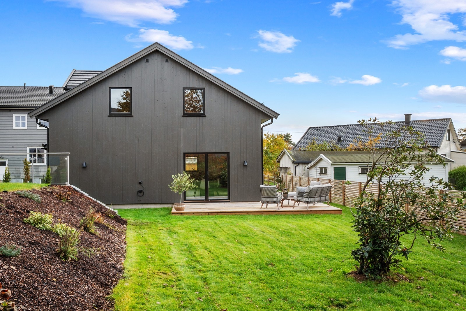 Uteområdene er opparbeidet med plen, beplantning og naturpregede skråningspartier. Tomten på 530 kvm er delvis inngjerdet med gjerde og rekkverk i glass. Galleribilde