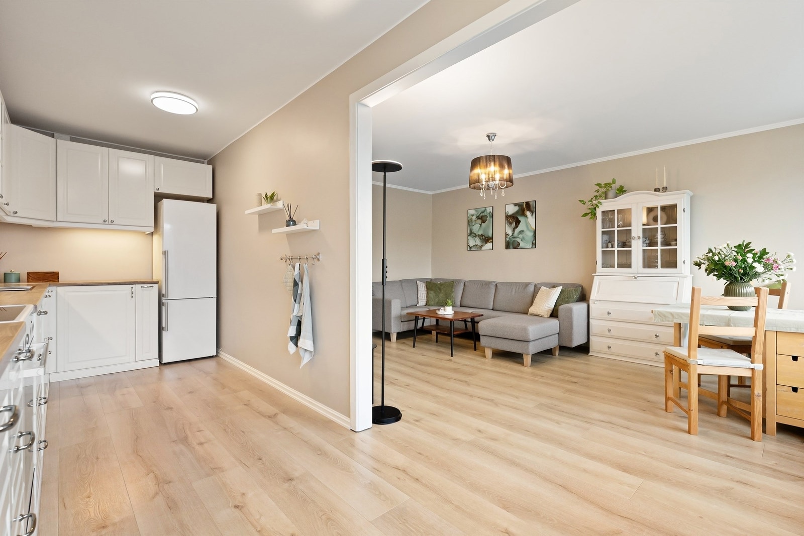 Lys og innbydende stue med delvis åpen løsning til kjøkkenet Galleribilde