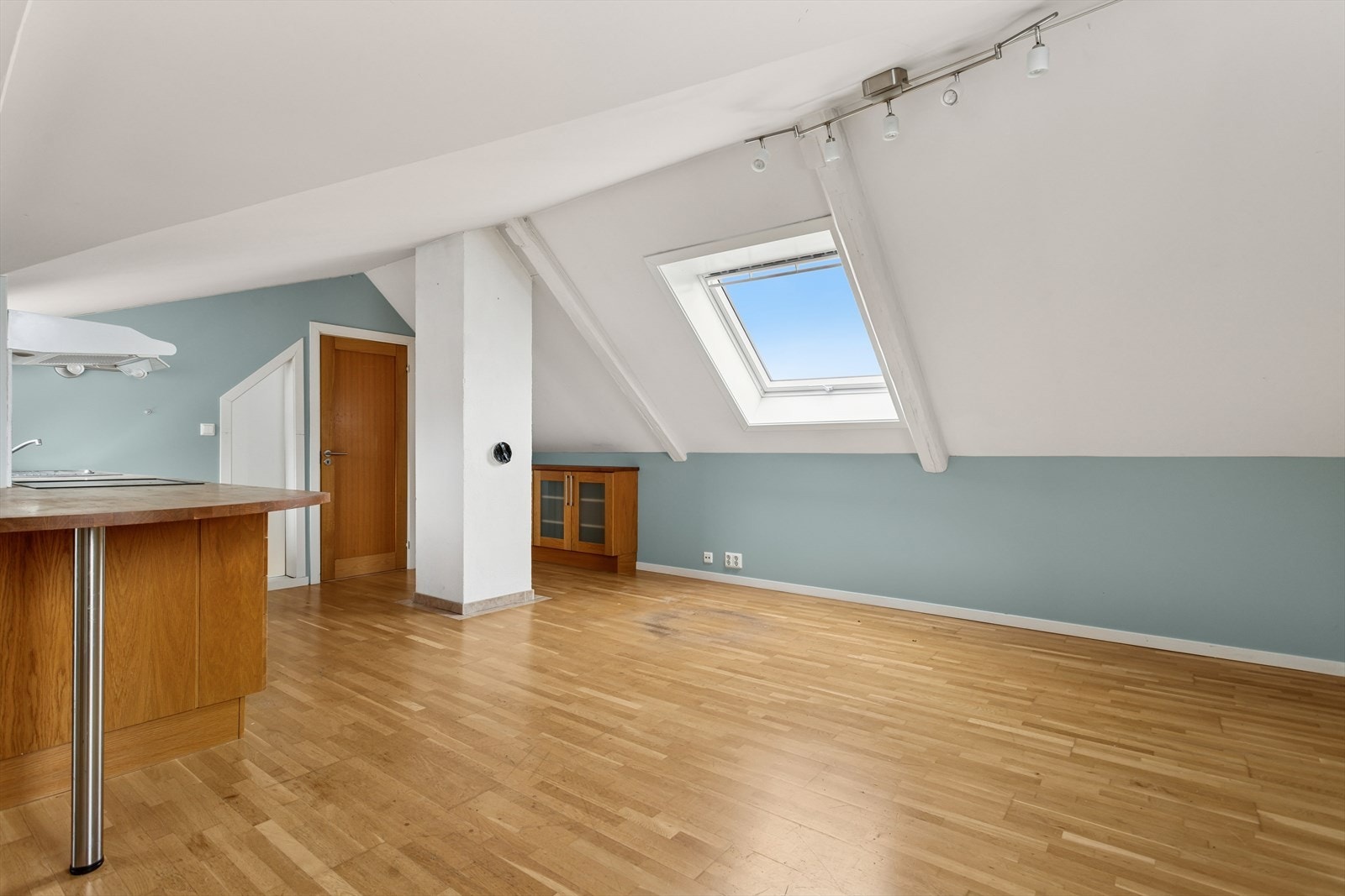 Parkettgulvet gir rommet en varm og naturlig følelse, mens det skrå vinduet slipper inn godt med dagslys. Galleribilde