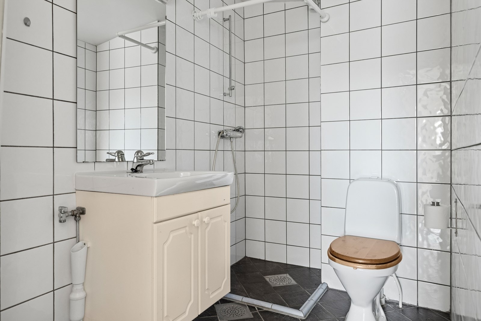 Baderommet er ca. 3,5 m² - baderommet har flislagte gulv og vegger. Dusjhjørne, servant med underskap, wc og opplegg for vaskemaskin. Galleribilde