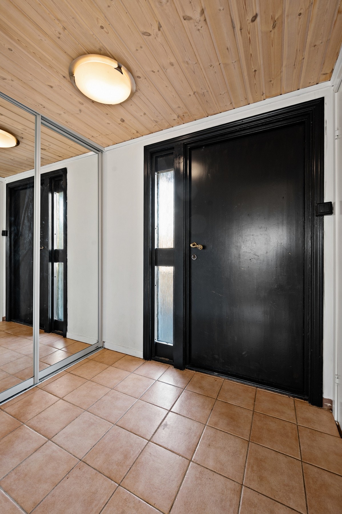 I entréen er det fliser på gulv og montert skyvedørsgarderobe med speilfronter. Galleribilde