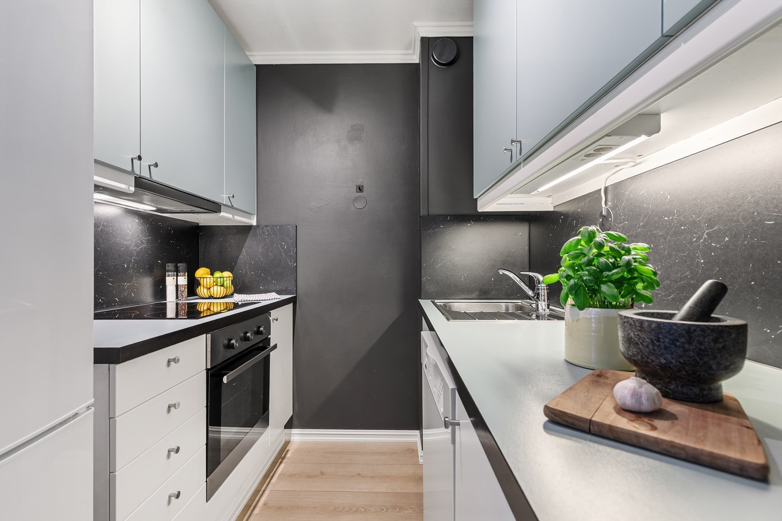 Kjøkkenet er i moderne toner og fremstår som pent med godt med skap og benkeplass Galleribilde