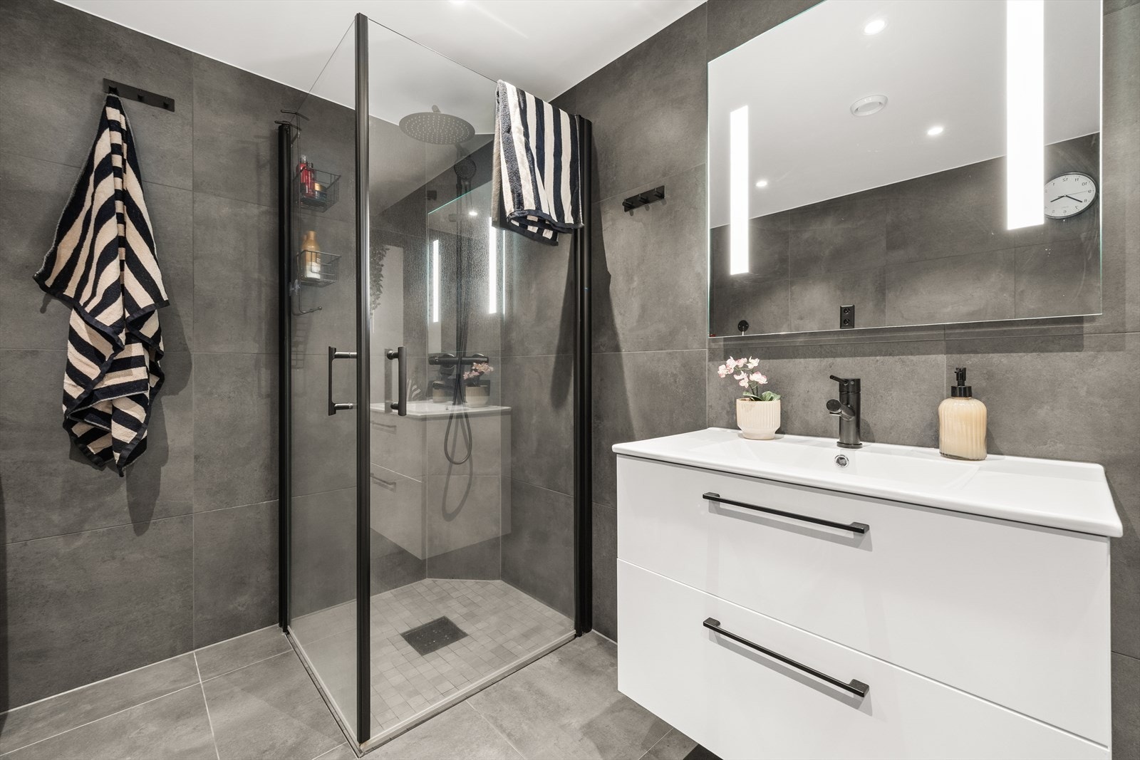 Badet er moderne og har delikat flisvalg på gulv og vegger Galleribilde