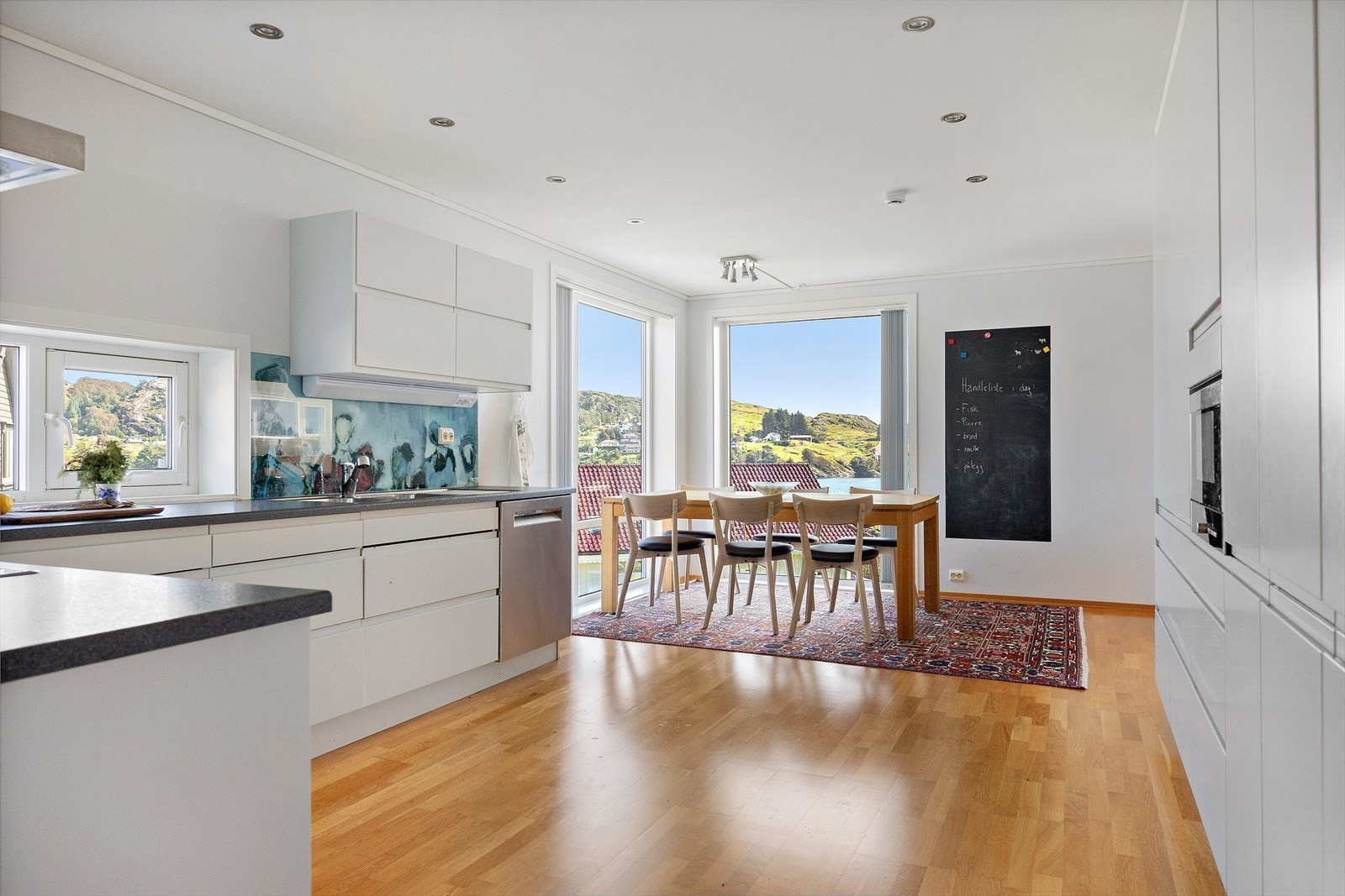 Benkeplaten av laminat har en elegant planlimt vask. Her finner du integrerte hvitevarer, som koketopp, stekeovn, mikrobølgeovn og en halvintegrert oppvaskmaskin. Galleribilde