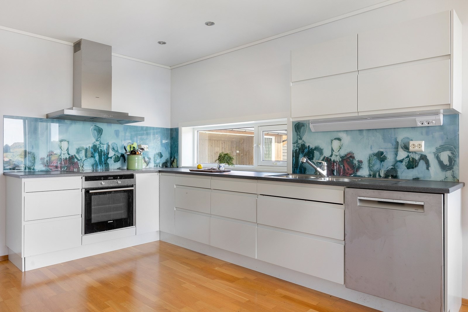 Kjøkkenet er stort, lyst og moderne, og har slette fronter med integrert grep for et rent og minimalistisk utseende. Galleribilde