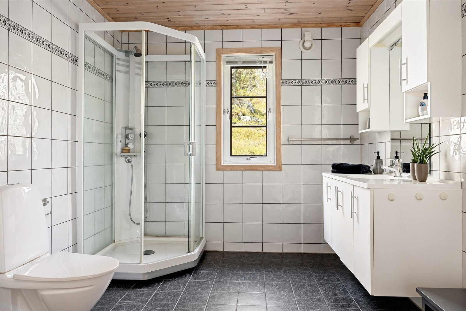 Hytten inneholder et godt utstyrt bad med toalett, dusjkabinett og innredning med nedfelt servant og opplegg for vaskemaskin. Galleribilde