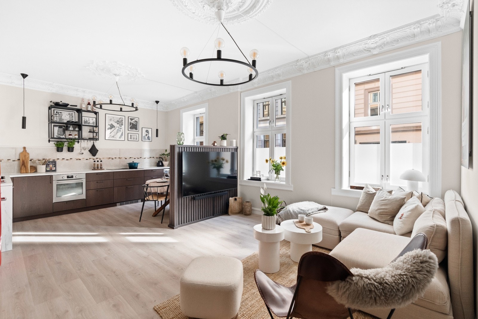 Praktisk halv-vegg etablert mellom stue og kjøkken for å separere sonene. Nåværende eier har innredet med spisebord på den ene sien av halv-veggen, og TV-oppheng med TV-krok på den andre siden - en velfungerende og særdeles praktisk løsning! Galleribilde