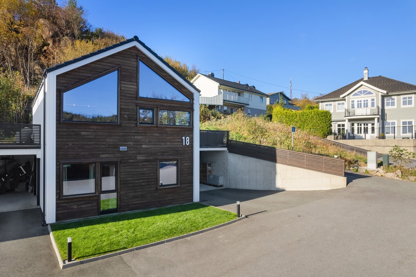 Tomten inkluderer også en asfaltert gårdsplass, en liten grønn plen og fine murer som rammer inn eiendommen på en pen måte. Galleribilde