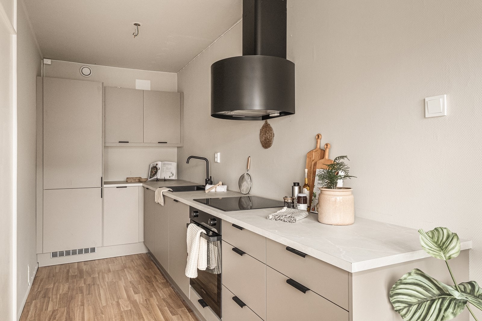 Nytt og moderne kjøkken med integrerte hvitevarer og stilren ventilator. God benkeplass og åpen løsning for sosial matlaging. Galleribilde