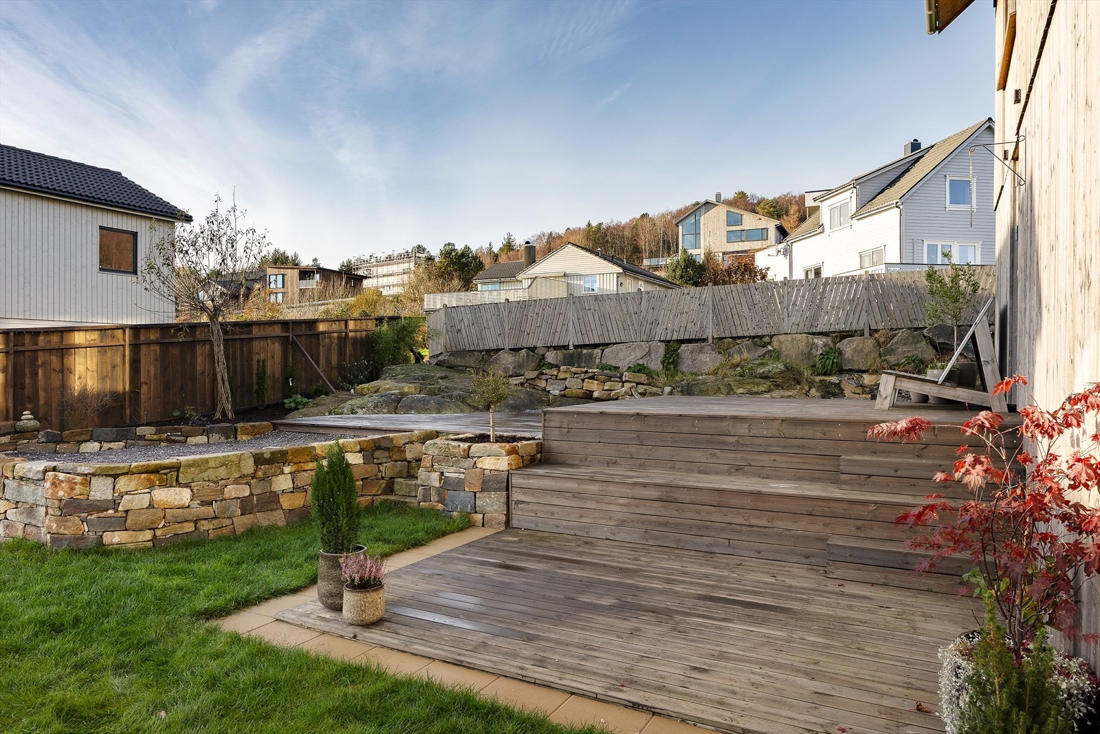 Denne eiendommen ligger på en pent opparbeidet tomt som byr på både plen, singel og terrasser fordelt over flere plan. Galleribilde