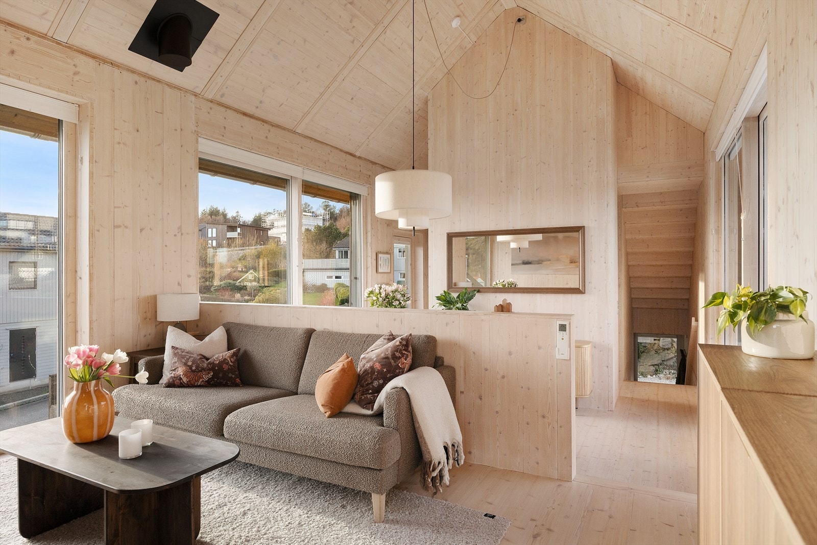 Stuen er boligens hjerte og kan beskrives som både innbydende og unik. Med høy himling og store vindusflater fylles rommet med naturlig lys og skaper en luftig atmosfære. Galleribilde