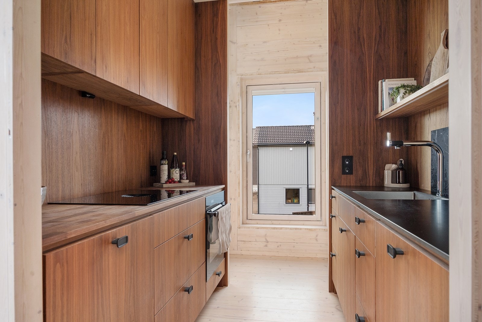 Med integrerte hvitevarer som kjøleskap i benk, stekeovn, koketopp og oppvaskmaskin er alt på plass for en moderne og effektiv matlagingshverdag. Galleribilde