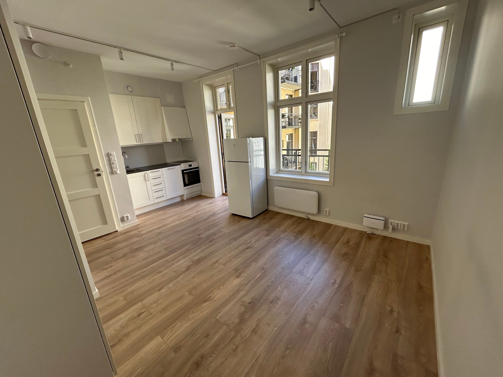 Oppholdsrom med åpen kjøkkenløsning og utgang til stor balkong. Galleribilde