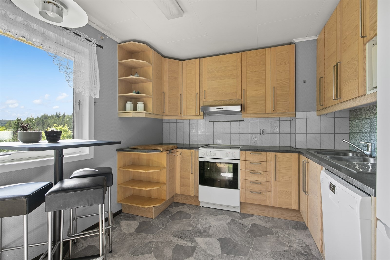 Kjøkkeninnredning med glatte, folierte fronter og laminert benkeplate. Galleribilde