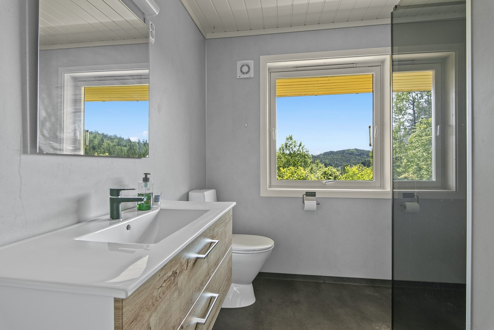 Flott bad med varmekabler og belegg på gulv, våtromsplater på vegg. Badet inneholder servant m/skap, wc og dusjhjørne. Galleribilde