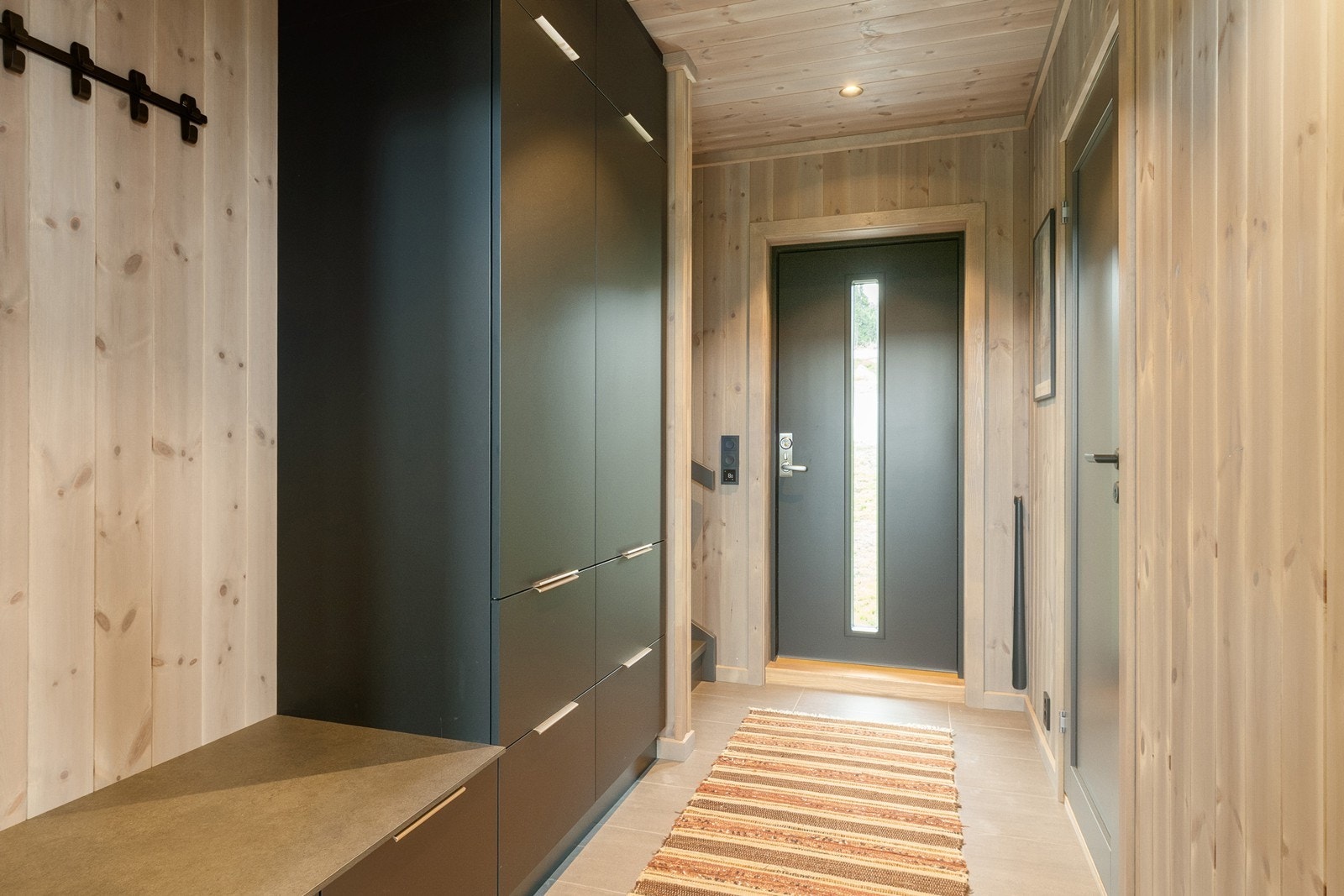 Ta steget inn i din nye hytte. I entreen er det gulv med fliser og varme. Rikelig med oppbevaringsmuligheter i garderobeløsning. Galleribilde