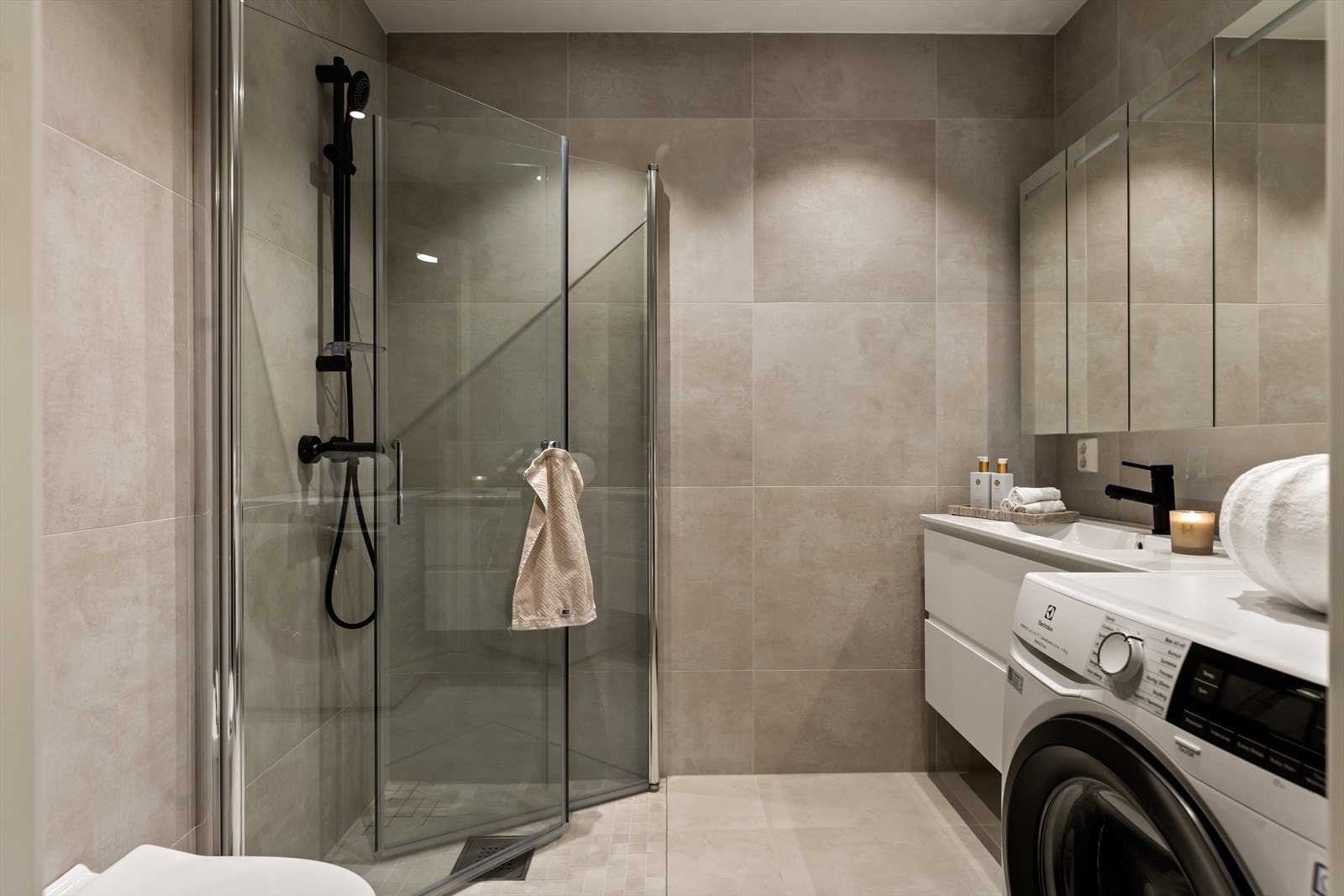 Lekkert baderom med store 60 x 60 fliser i delikat beige, samt mosaikk i dusjsonen. Varme i gulvet Galleribilde