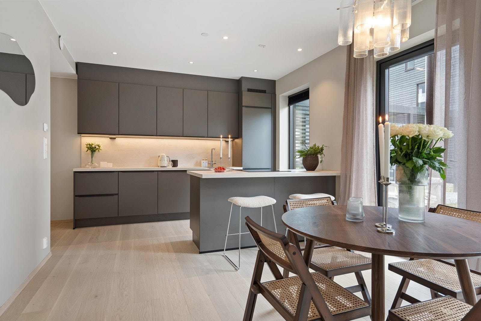 Moderne, fin kjøkkeninnredning fra KEO med god benkebelysning innfelt i overskapene Galleribilde