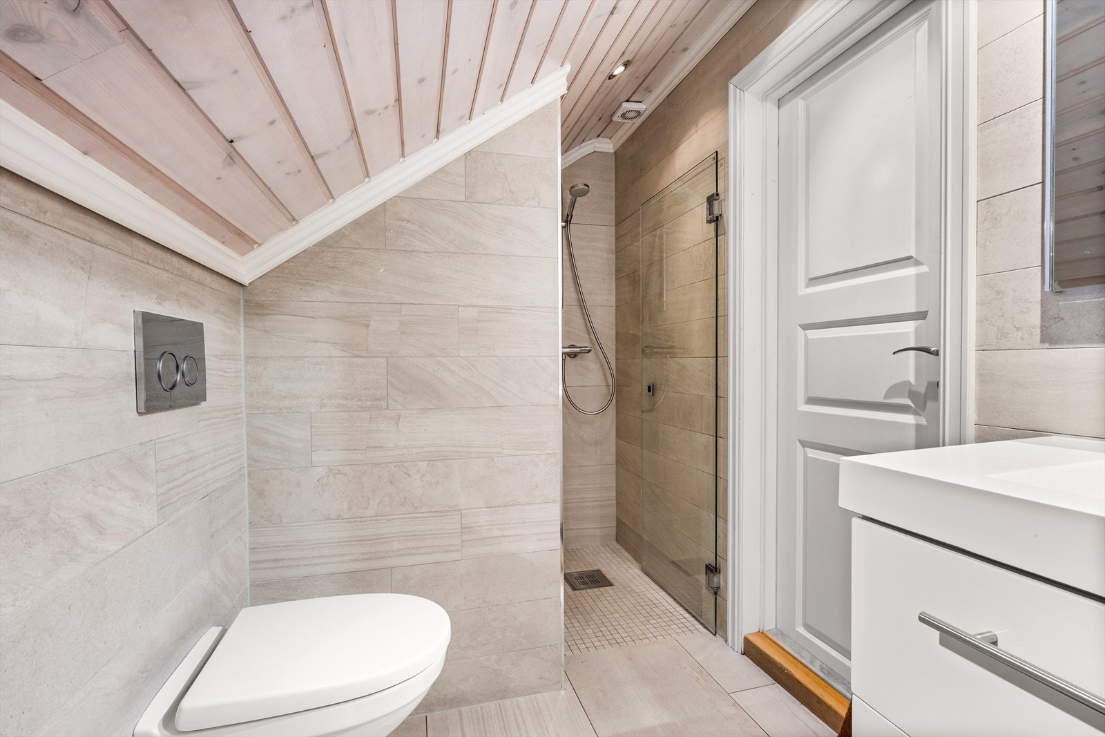 Pent flislagt bad i 2. etasje (pusset opp i 2013) med varmekabler i gulv, downlights i tak, veggmontert klosett, baderomsinnredning med servant og dusjnisje med glassdør. Galleribilde