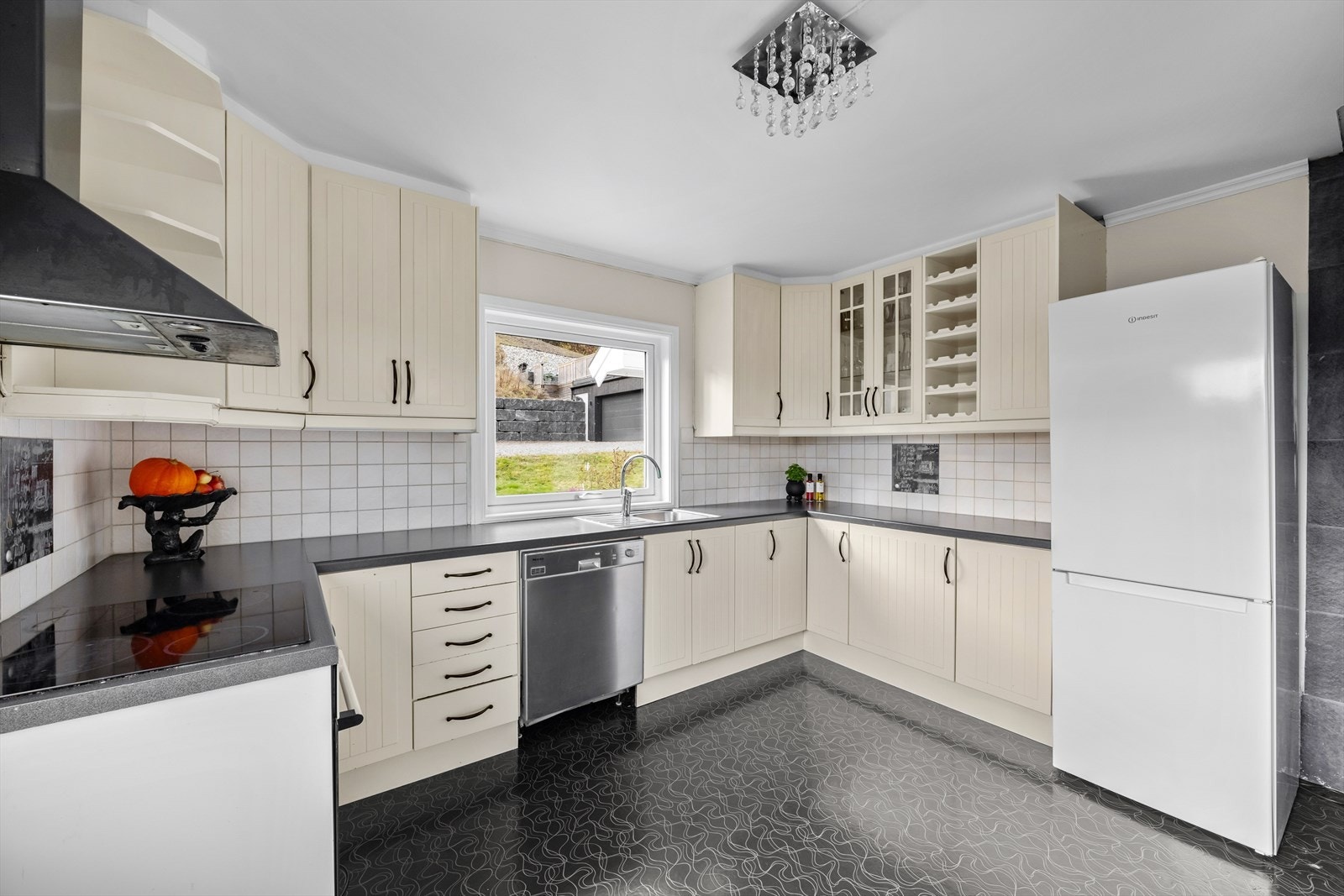 Vegg over kjøkkenbenk er flissatt. Galleribilde