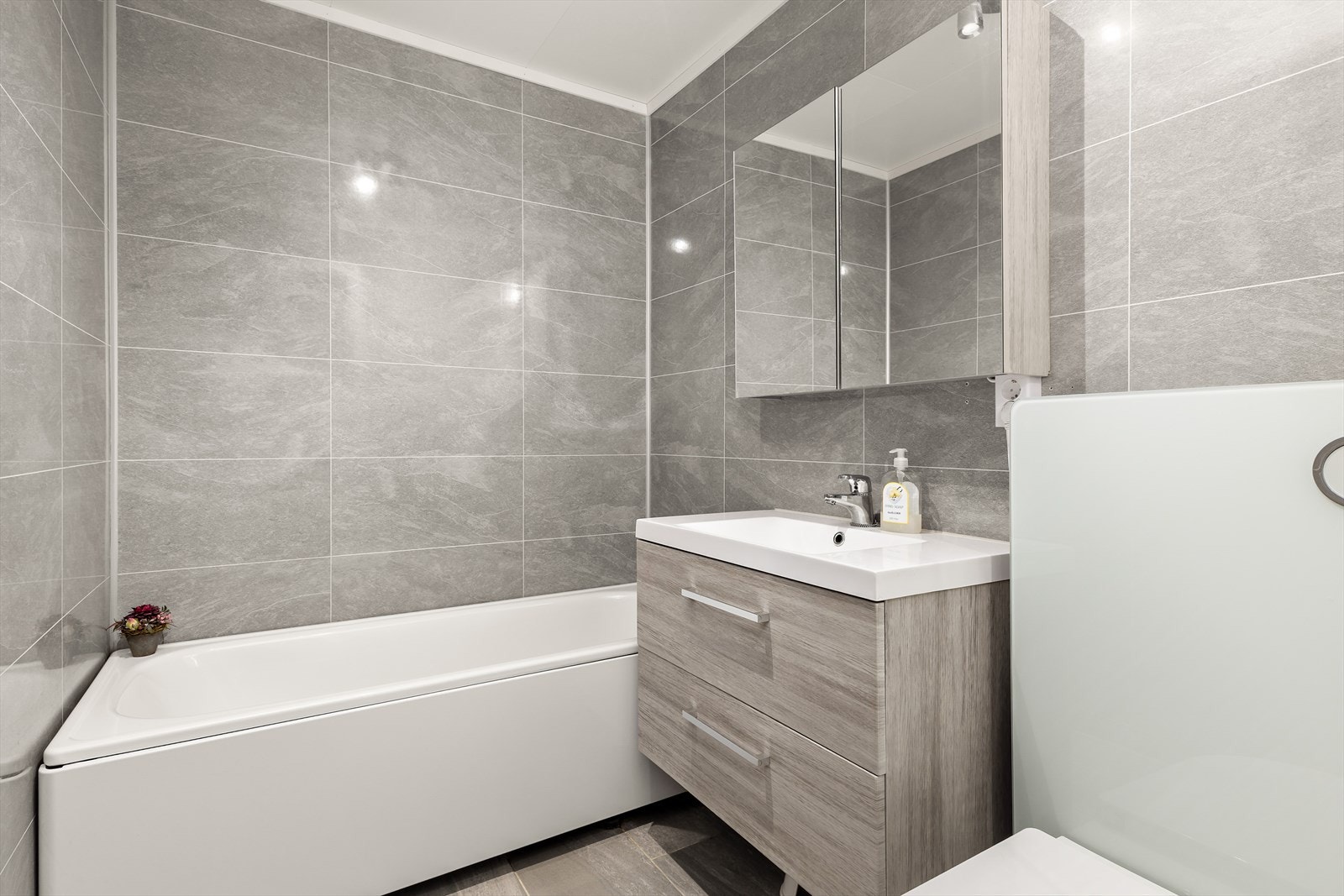 Pent baderom som ble oppusset i 2017 med våtromsplater på vegger og flislagt gulv med varmekabler. Galleribilde