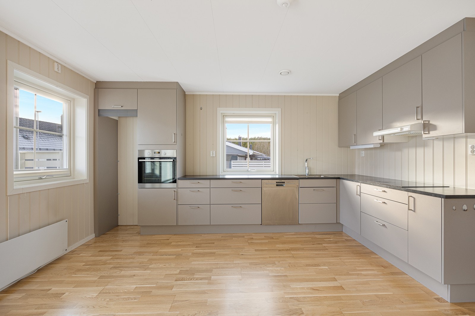 Kjøkkenet har oppvaskmaskin, og integrert i innredningen finner man stekeovn og induksjonstopp Galleribilde