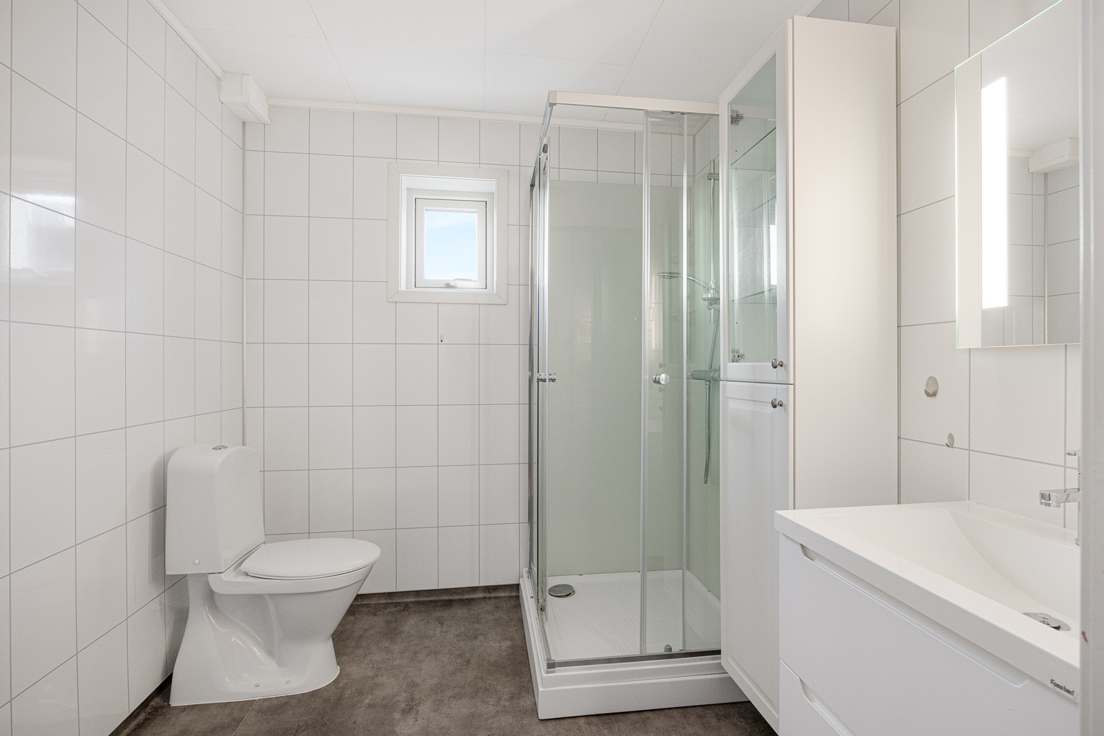 Badet har opplegg for vaskemaskin, toalett, varmekabler og dusjkabinett Galleribilde