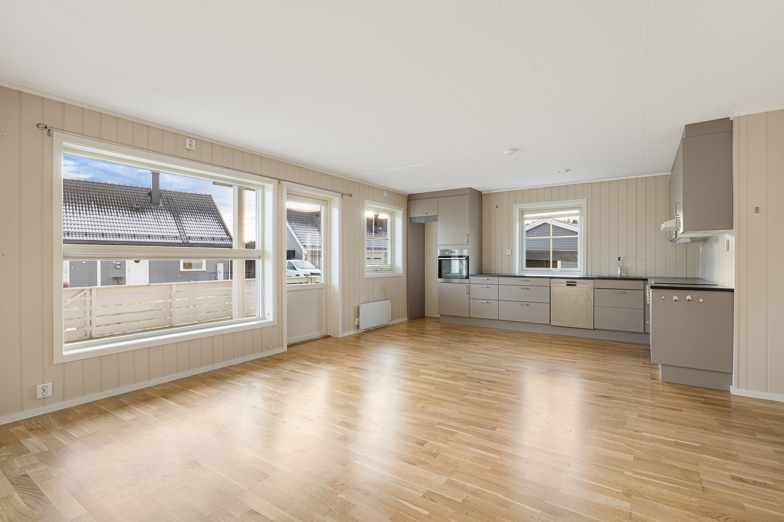 Kjøkkenet er stilrent og luftig, oppført i en funksjonell L-form med god skap- og benkeplass Galleribilde