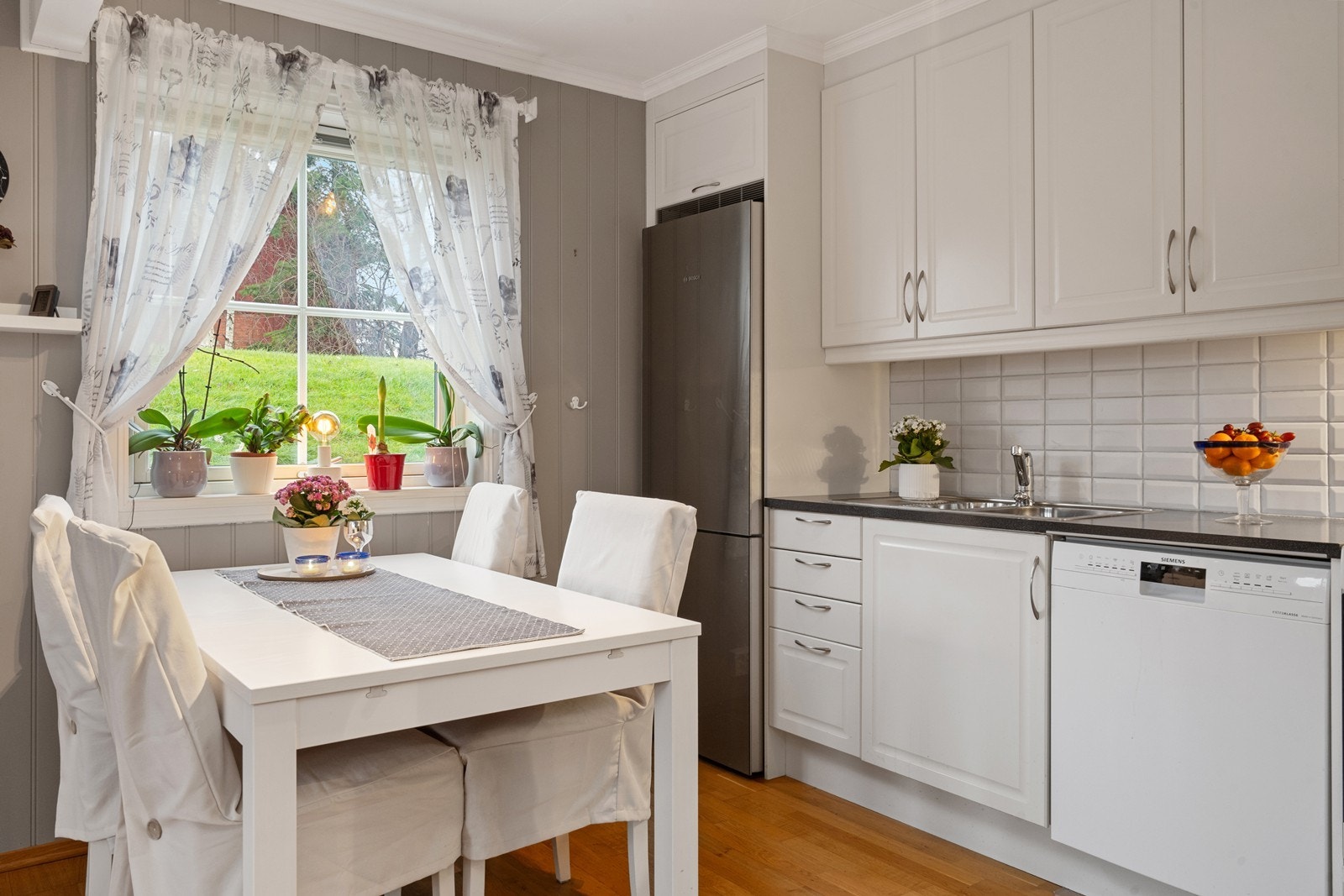 Kjøkkenet har profilerte, lyse fronter og laminerte benkeplater fra byggeåret. Galleribilde