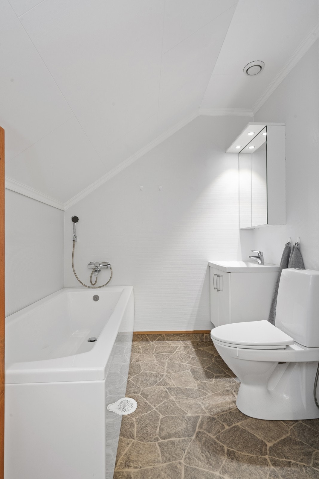 Badet i 2. etasje har belegg på gulvet og malt glassfiberstrie på veggene, med ventilasjon tilkoblet ventilasjonssystemet (kilde: tilstandsrapport). Galleribilde