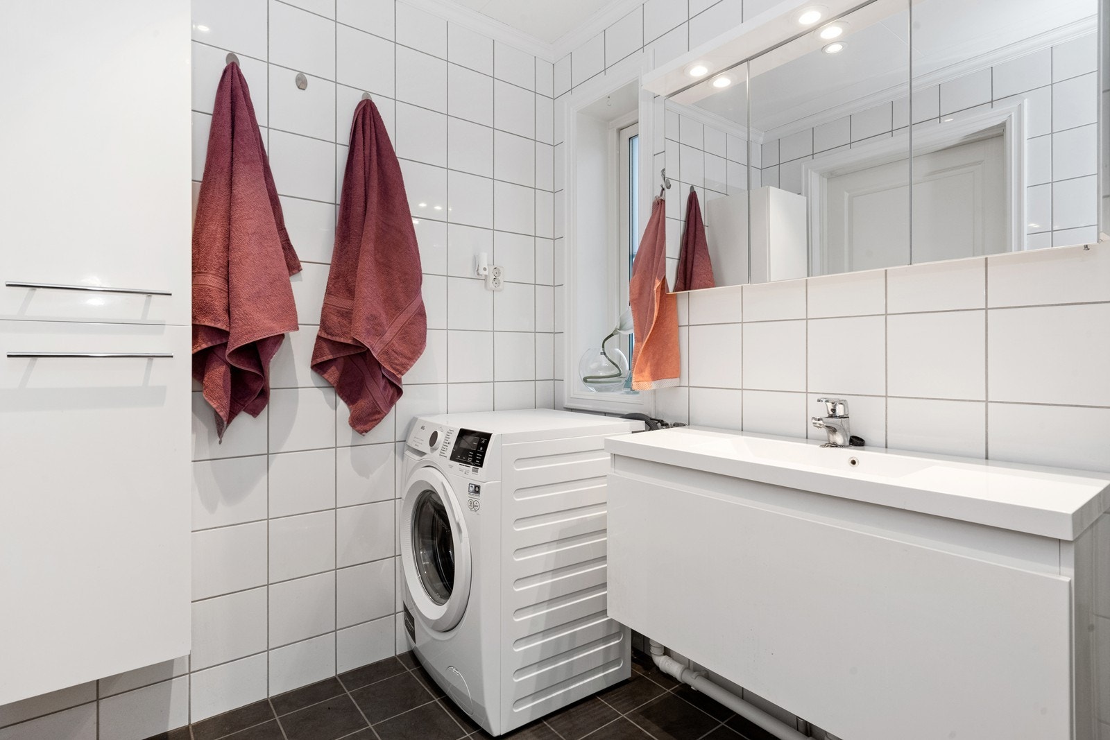 Opplegg og plass til vaskemaskin gjør vaskerommet praktisk og funksjonelt. Galleribilde