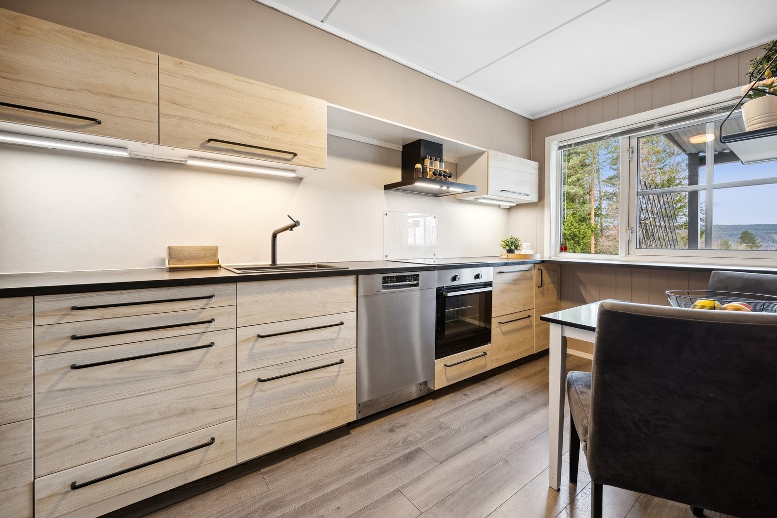 Lekkert kjøkken med innredning fra Ikea og moderne sorte detaljer som komposittvask, armatur og benkeplate. Galleribilde