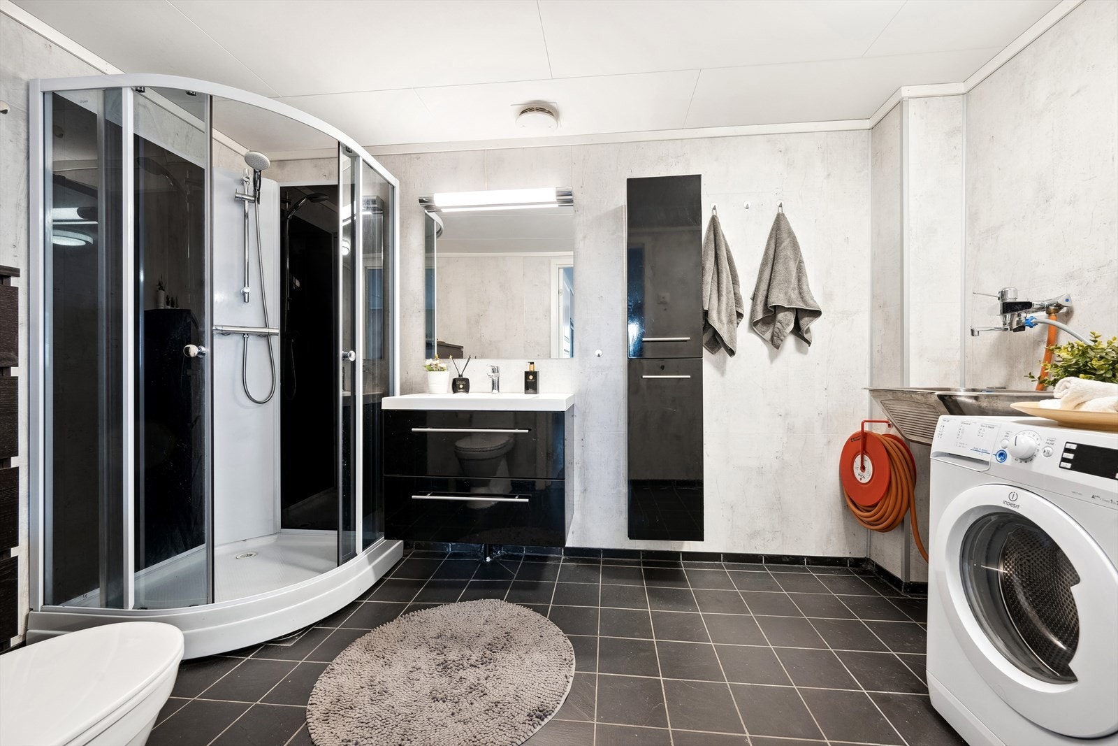 Badet har fliser på gulv og gulvvarme. På vegg er det montert våtromsplater. Galleribilde