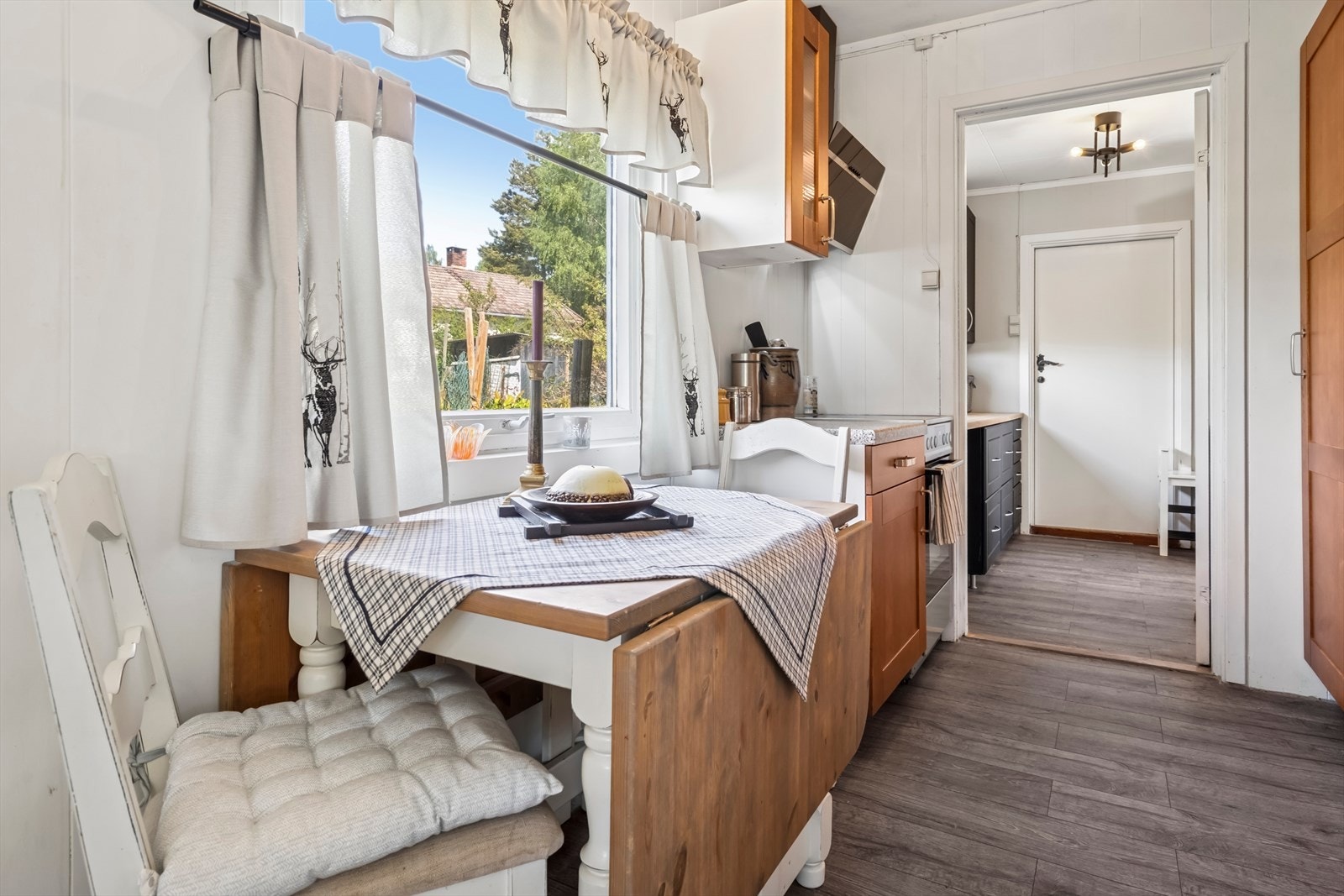 Kjøkkenet inneholder frittstående hvitevarer som komfyr, avtrekksvifte og kjøl/frys Galleribilde