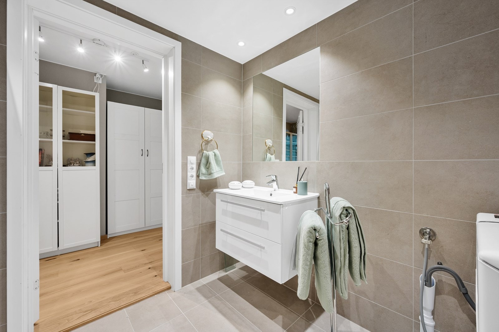 I tillegg til et vegghengt toalett har badet opplegg for vaskemaskin og et dusjhjørne med innfellbare glassdører. Galleribilde