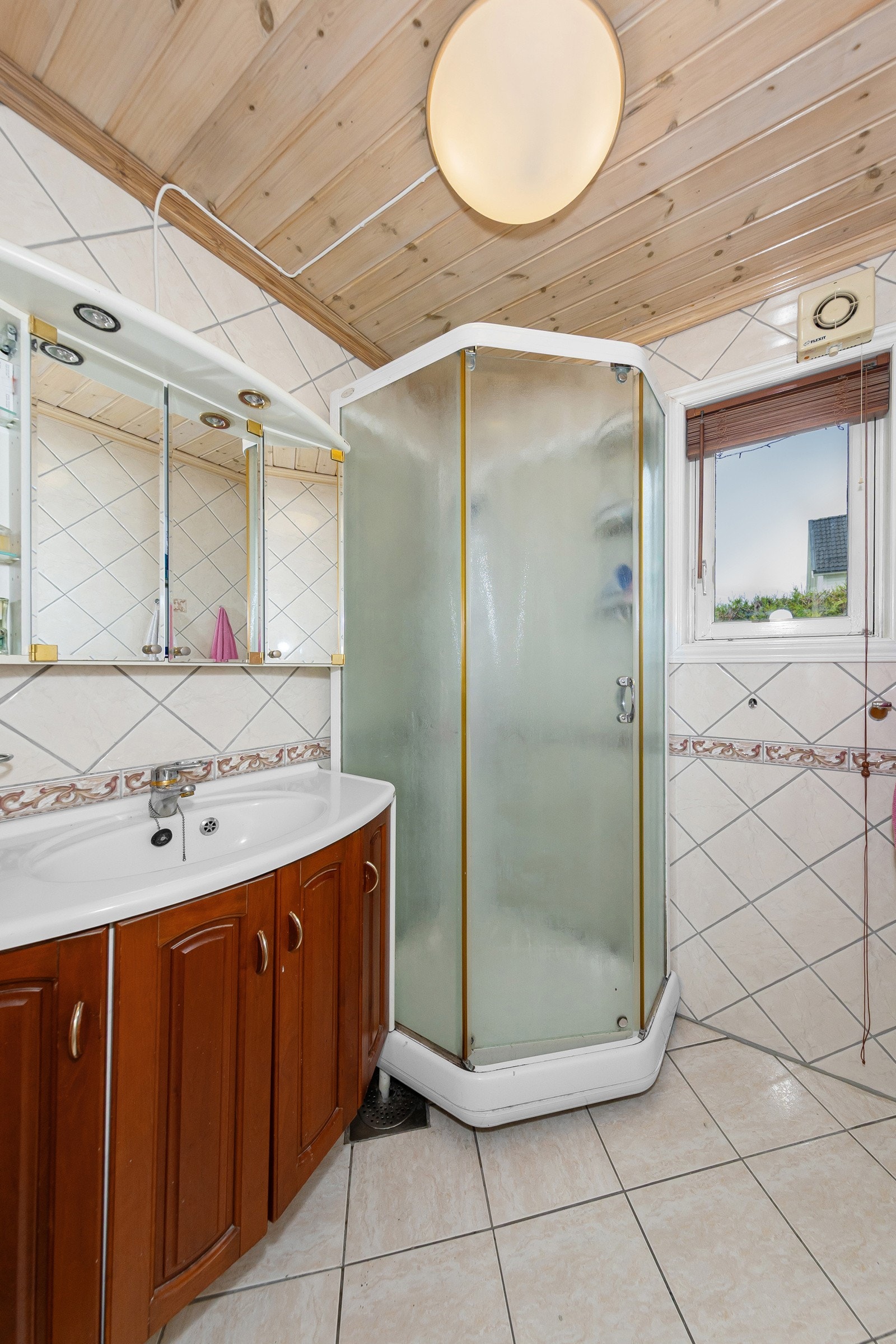 Bad i 1. etasjen med dusjkabinett, servantskap med god plass til oppbevaring, vask av grei størrelse og speilskap med oppbevaring. Galleribilde