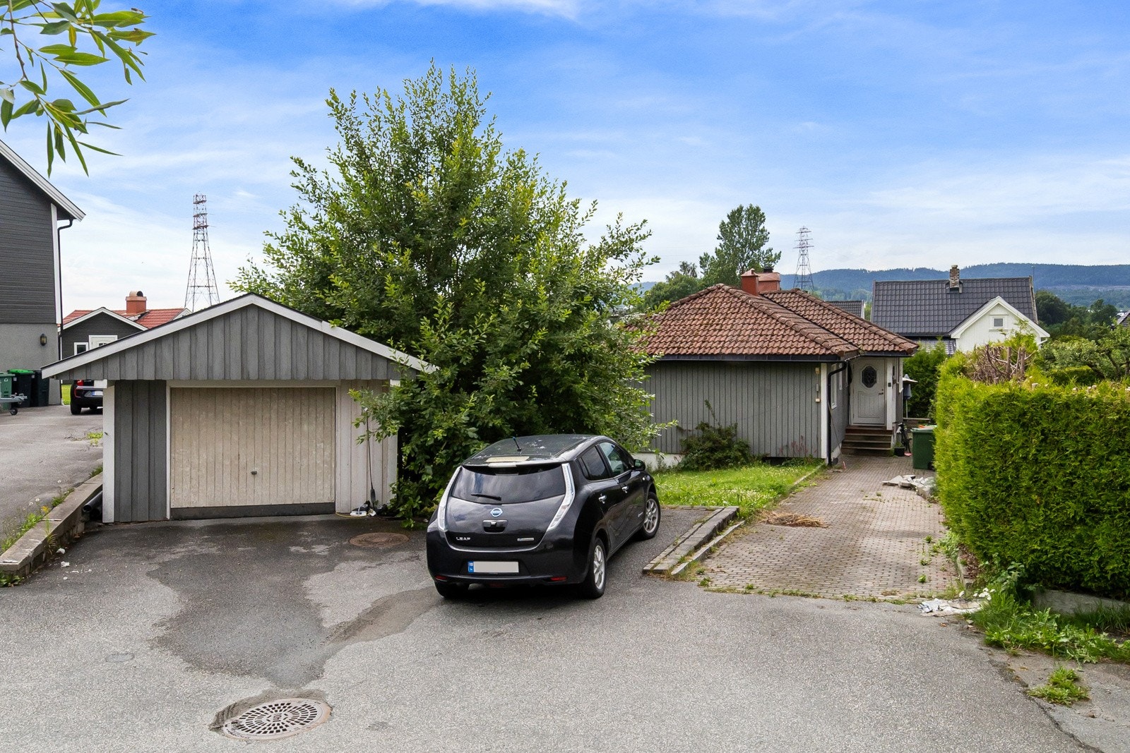 Boligen har en usjenert tomt og frittstående garasje. Galleribilde