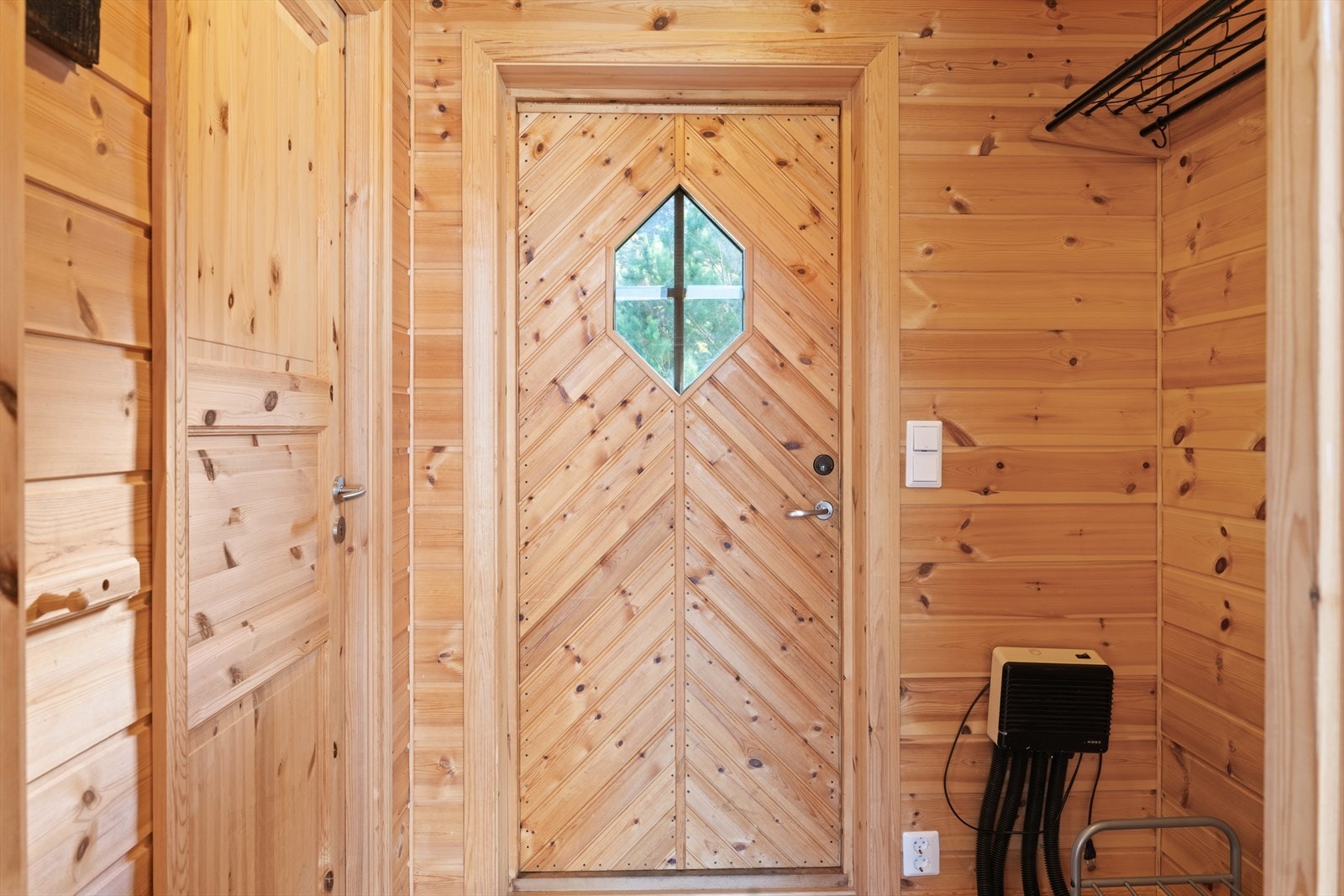 Velkommen inn! Hyggelig og praktisk entré som ønsker deg velkommen inn i hytta med lune furupaneler og gjennomført hyttestil. Her er det god plass til å henge yttertøy og sette fra seg sko, og fra entréen har du også direkte tilgang til en praktisk bod. Galleribilde