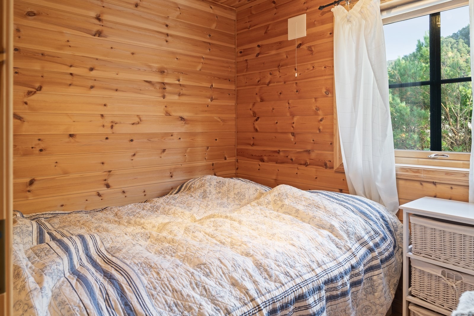 Hytta har tre lyse og trivelige soverom, alle innredet i gjennomført stil med varme furupaneler som skaper en rolig og lun atmosfære. Her senker du skuldrene og finner hvilepulsen - et sted hvor naturens stillhet og frisk luft gjør nettene ekstra gode! Galleribilde