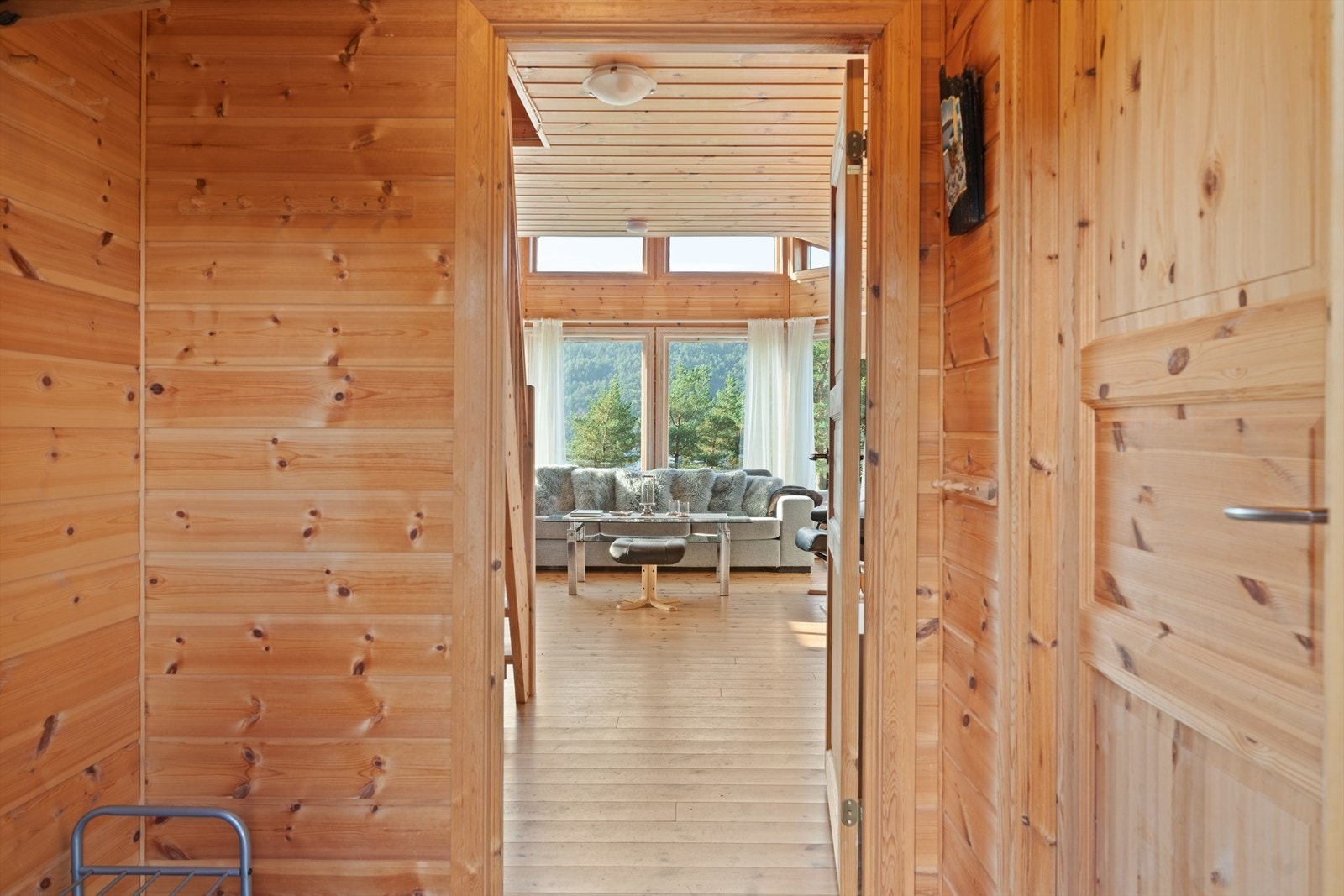 Rommet gir et godt førsteinntrykk av den varme og autentiske atmosfæren som preger resten av hytta, og leder deg videre inn til den lyse og innbydende stuen. Galleribilde