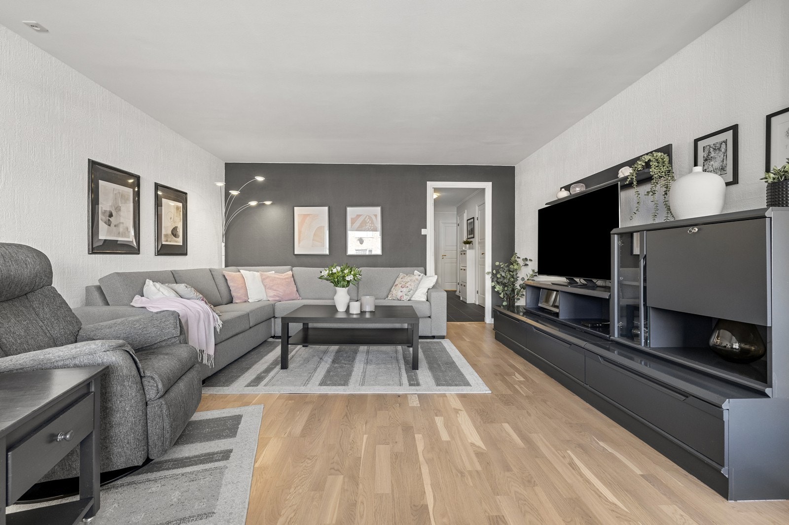 Leiligheten har en lys og romslig stue med flere møbleringsmuligheter. Gulv av parkett og vegger av malt strie. Galleribilde