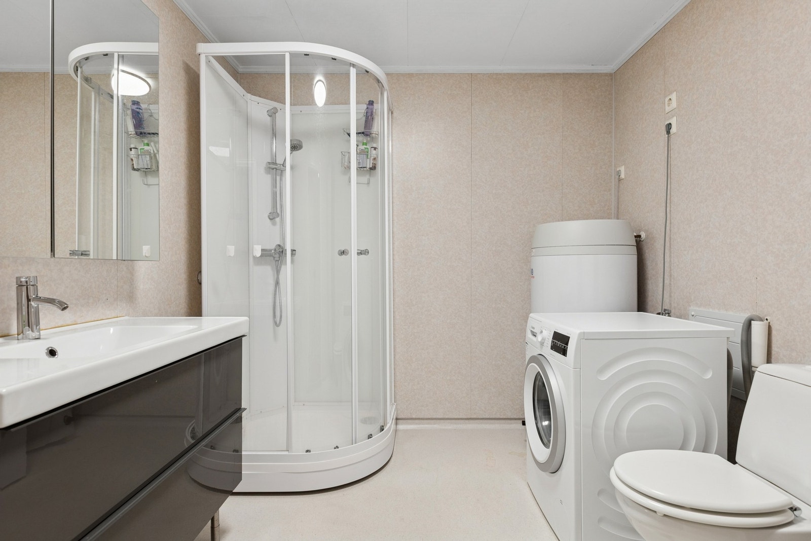 Romslig og praktisk bad med dusjkabinett, servant med underskap og god oppbevaringsplass. Galleribilde