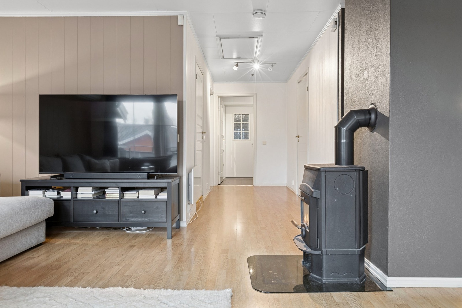 Den vedfyrte peisen gir ekstra varme og stemning på kjølige dager, og bidrar til en lun og hyggelig oppholdsdel. Galleribilde