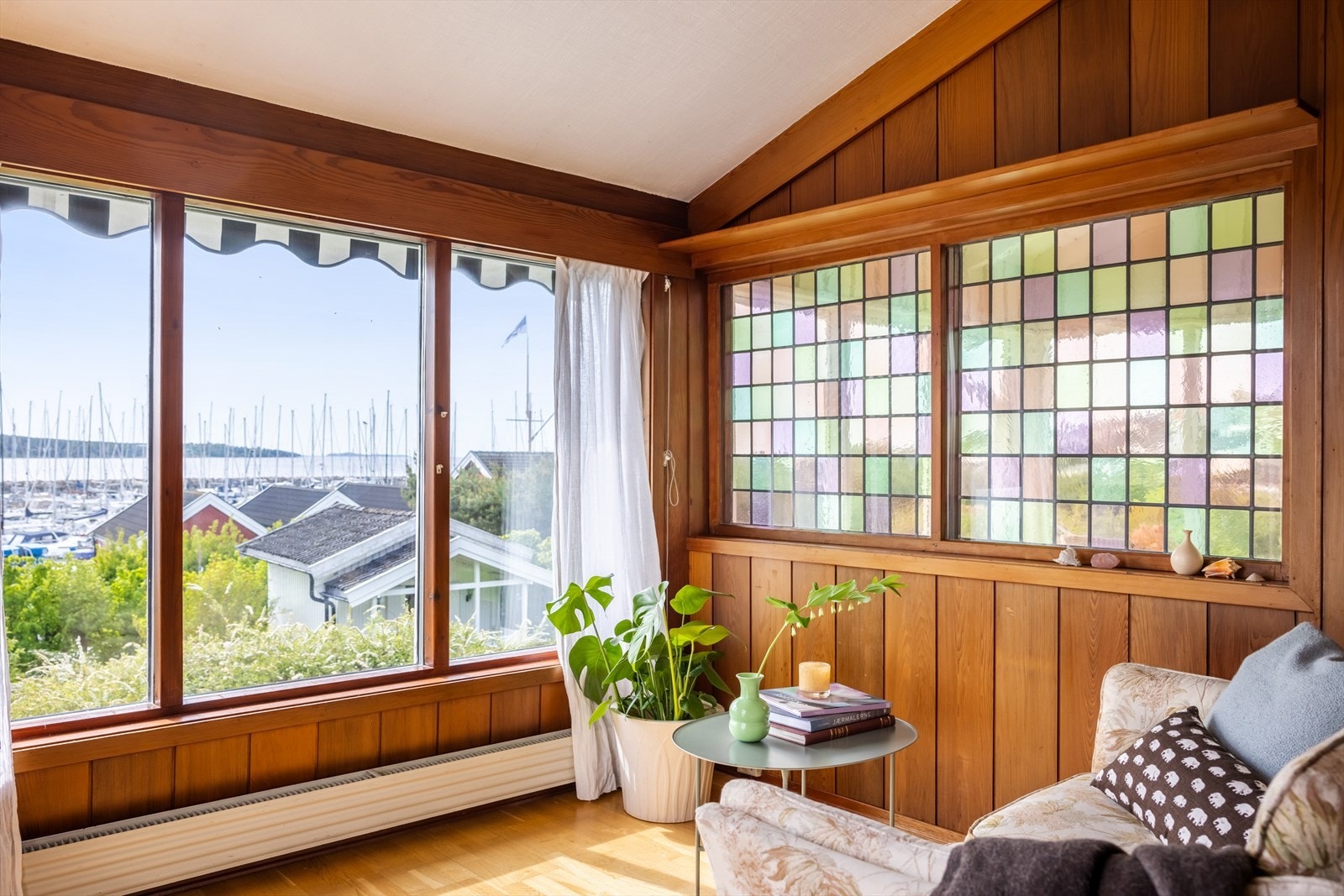 Det er klassisk eikeparkett på gulv og flere vinduer har fargerikt blyglass. Galleribilde