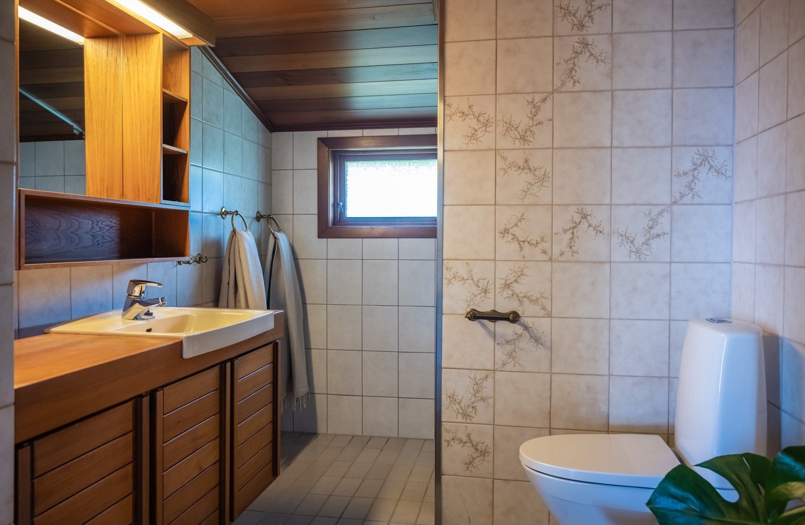 Boligen har to bad, ett i hver etasje. Bad i 1. etg. har flislagte overflater, redwoodpanel i tak, god oppbevaringsplass og dusjnisje. Galleribilde